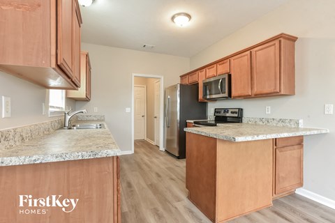 A kitchen with wooden cabinets and a granite countertop.