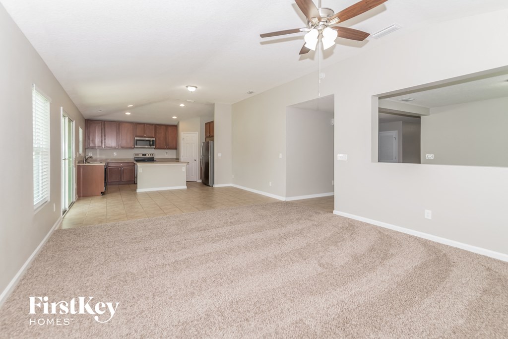 A spacious room with a fan and a carpeted floor.