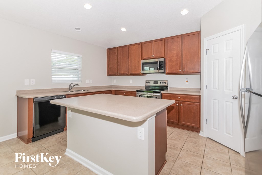 A kitchen with brown cabinets and a white island.