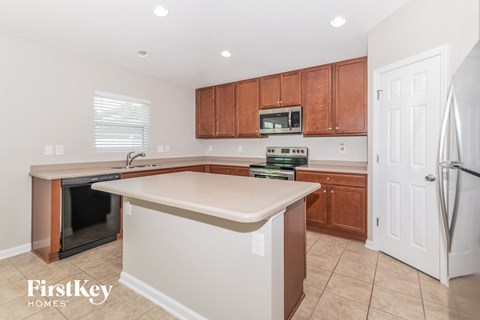 A kitchen with brown cabinets and a white island.