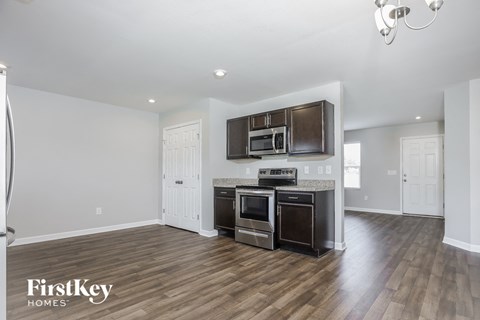 A kitchen with a stove top oven and microwave above it.