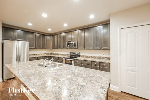 A kitchen with a marble countertop and stainless steel appliances.