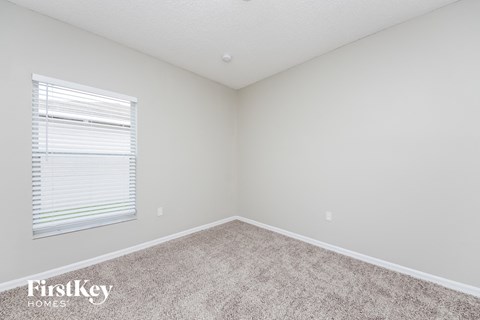 the upstairs bedroom has carpet and a large window