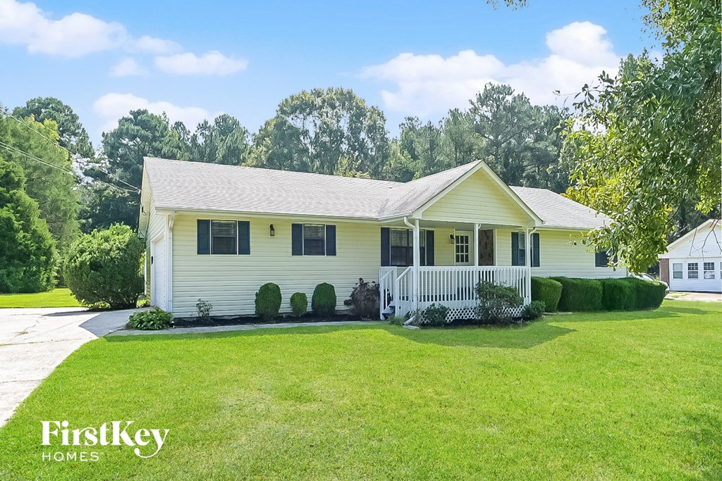 a white house with a lawn and a white fence