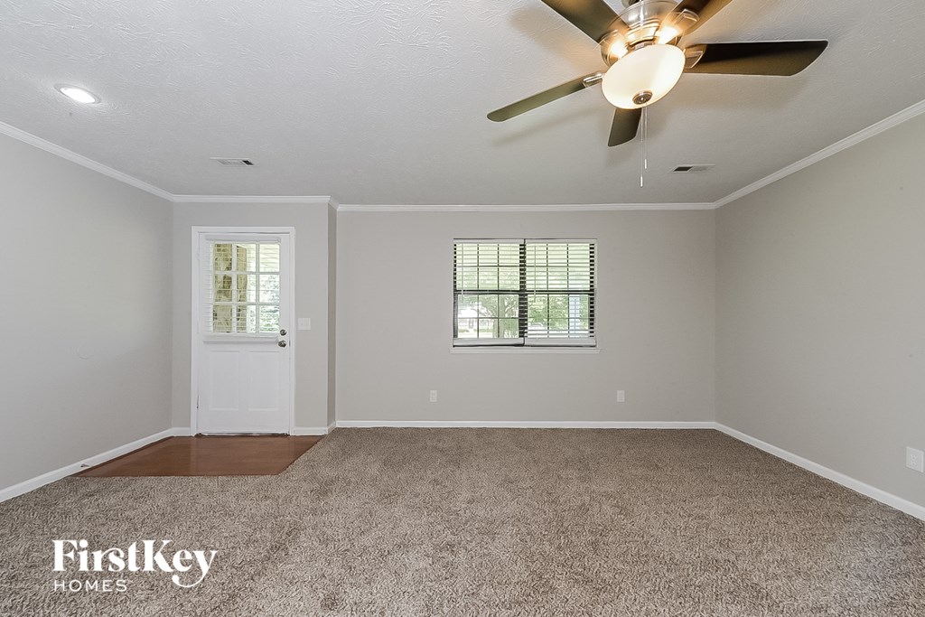 the living room of an empty house with a ceiling fan