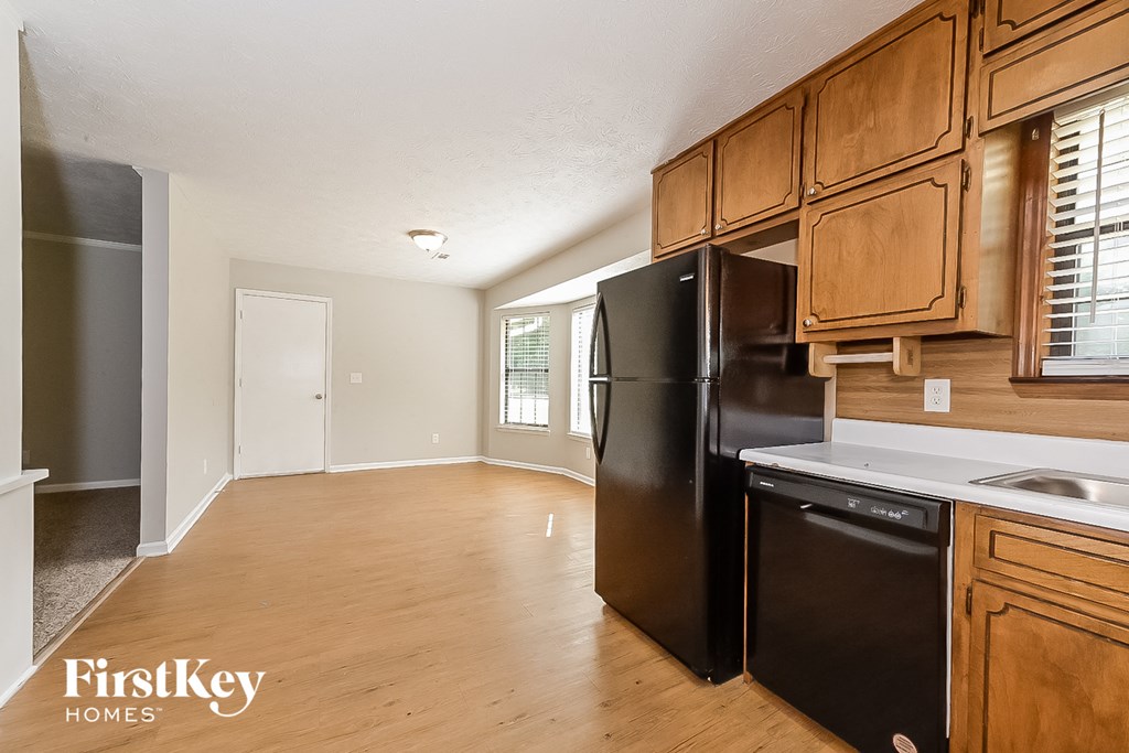an empty kitchen with black appliances and wooden cabinets