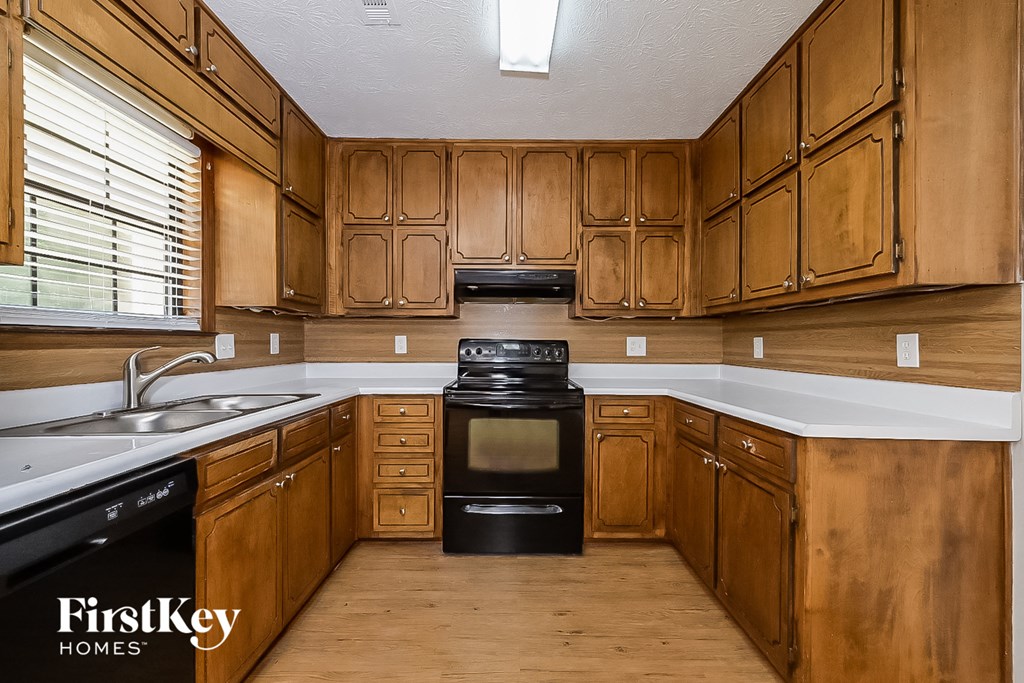 a kitchen with wooden cabinets and a stove and a sink