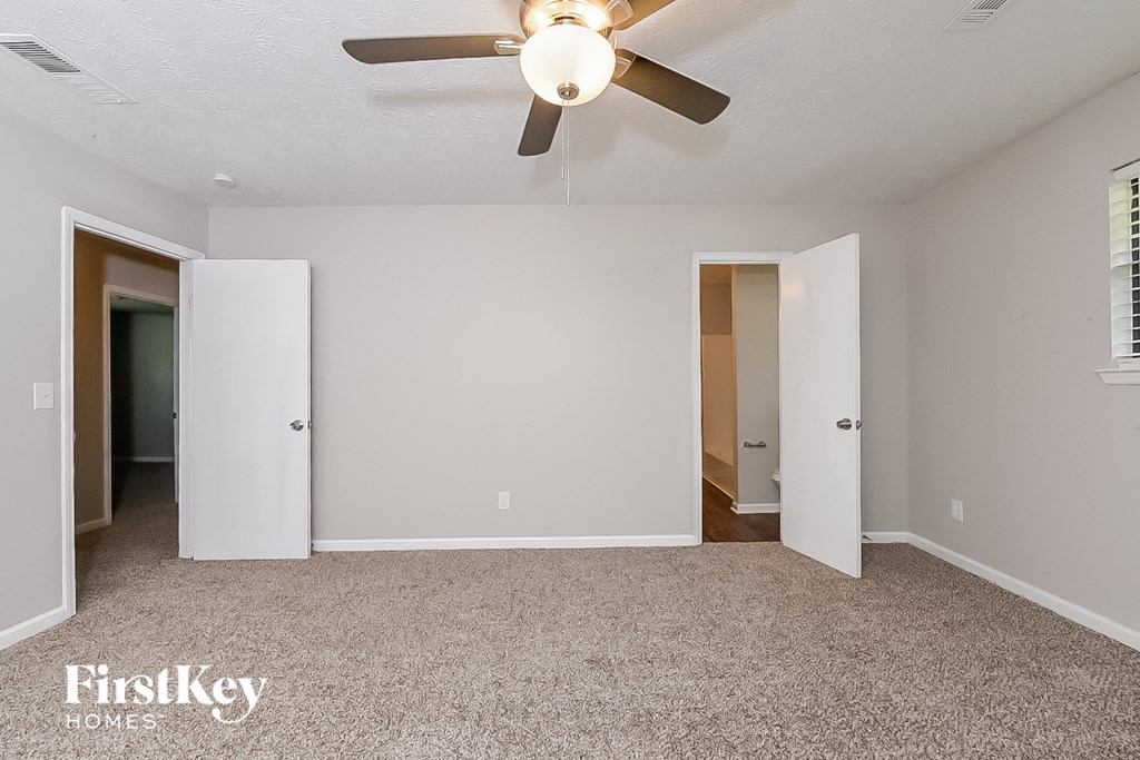 the living room of an empty house with a ceiling fan