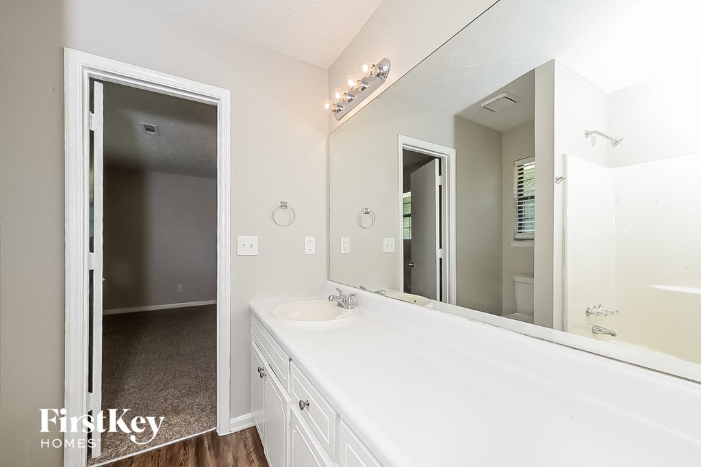 a white bathroom with a large mirror and a sink