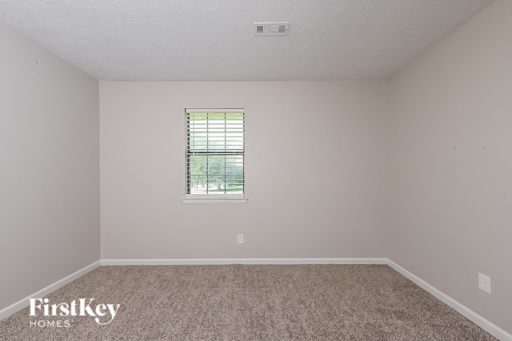 a empty room with carpet and a window