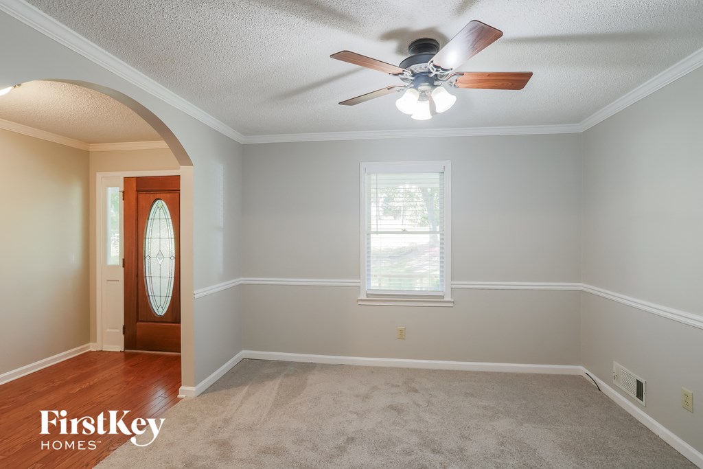 a living room with a ceiling fan and a window and a door