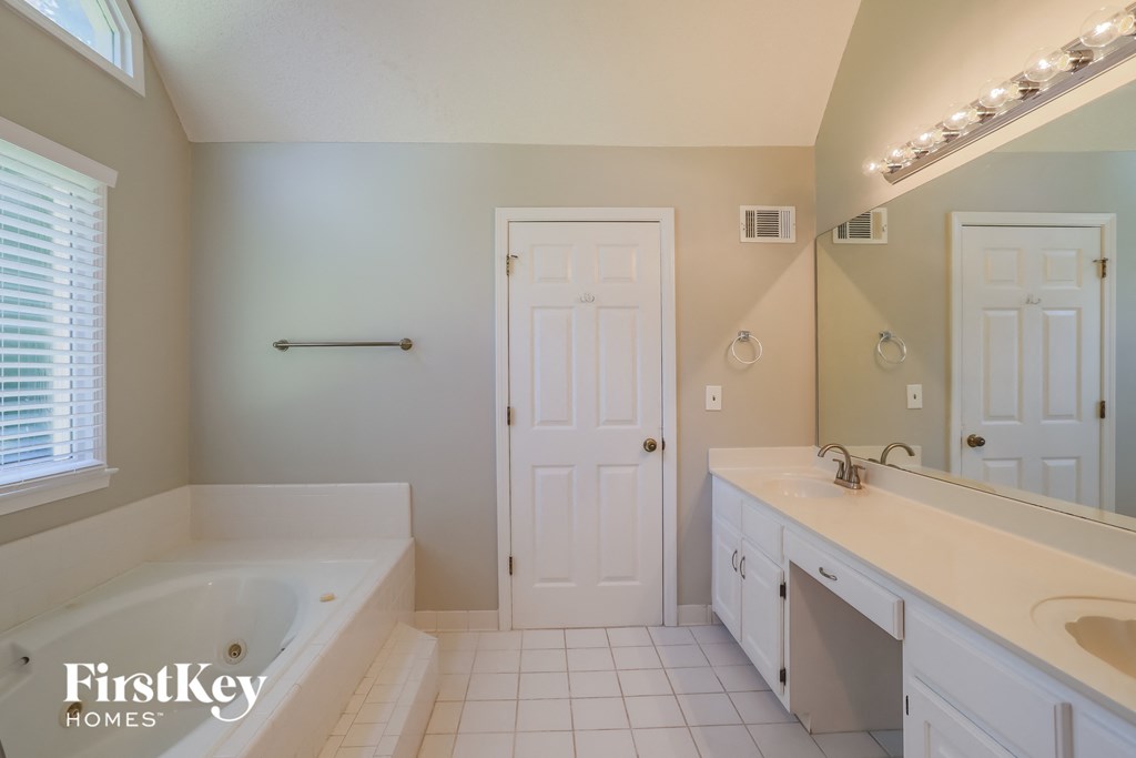 a bathroom with a tub and a sink and a mirror
