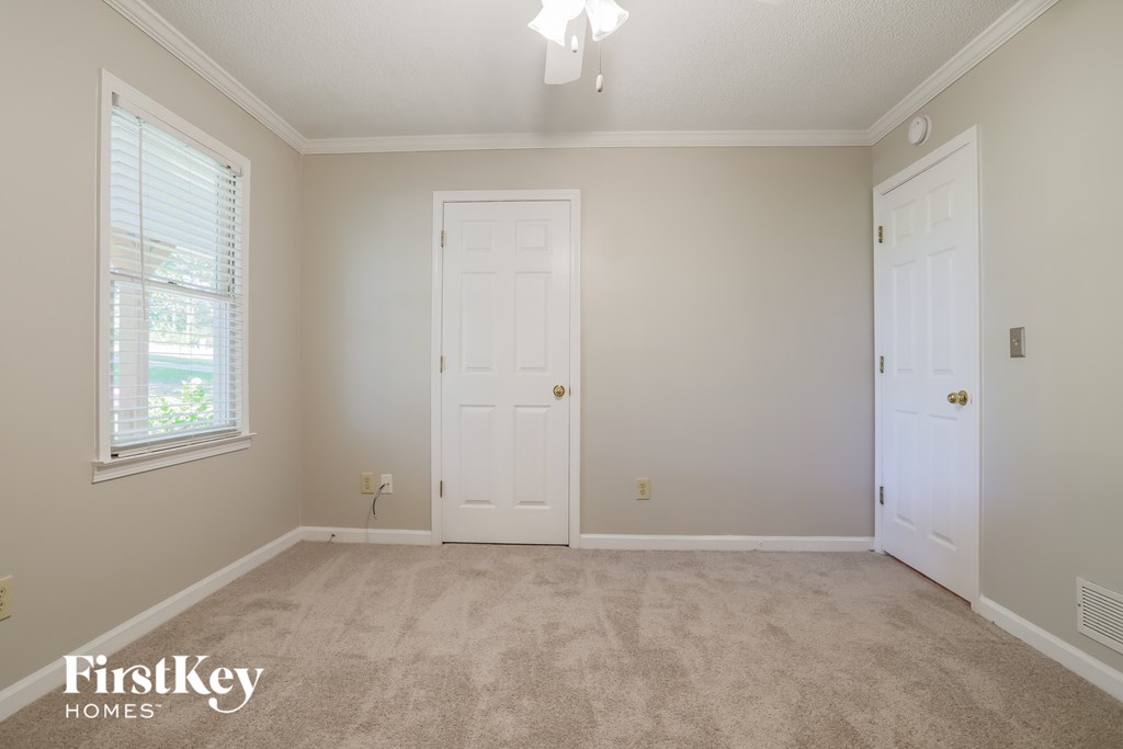 a bedroom with a carpeted floor and two white doors
