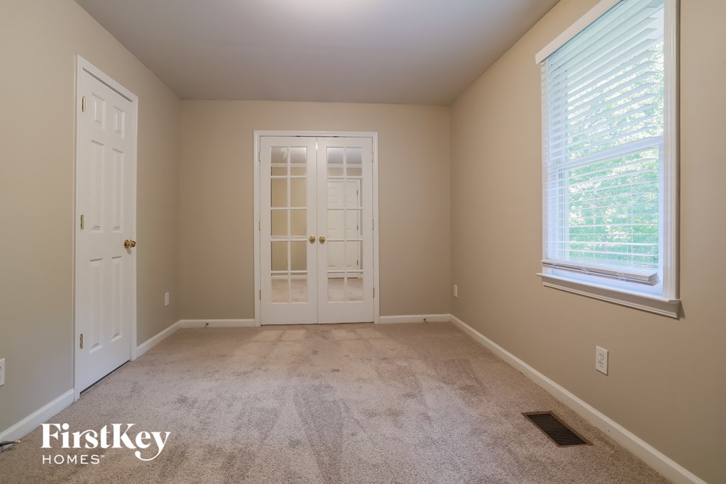 a room with carpet and a door and a window