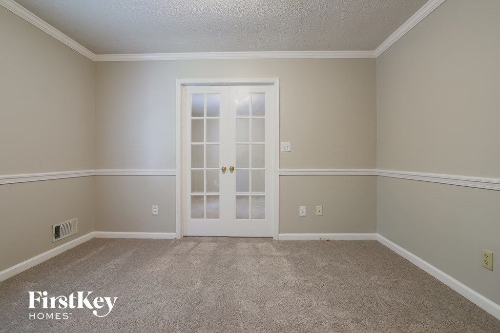 a empty living room with a door to a closet