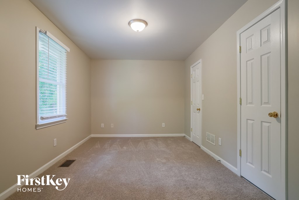 a bedroom with a carpeted floor and a white door