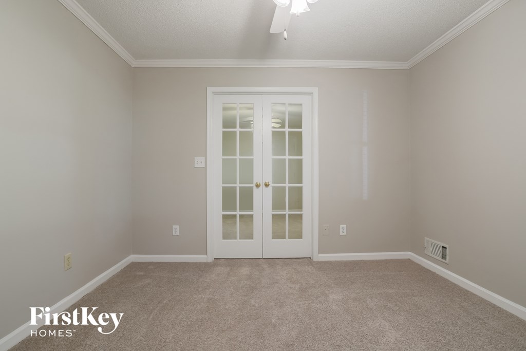 a empty living room with white doors and carpet
