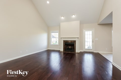 the living room with hardwood floors and a fireplace