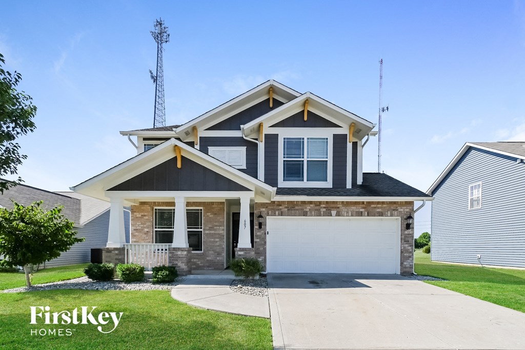 a house with a garage door and a lawn