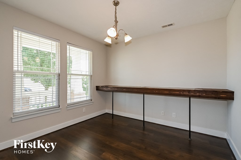 a dining room with a large table and two windows