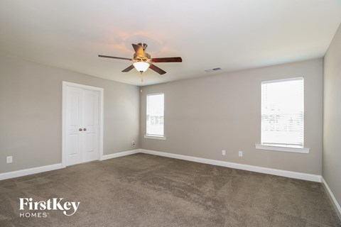 a living room with carpet and a ceiling fan