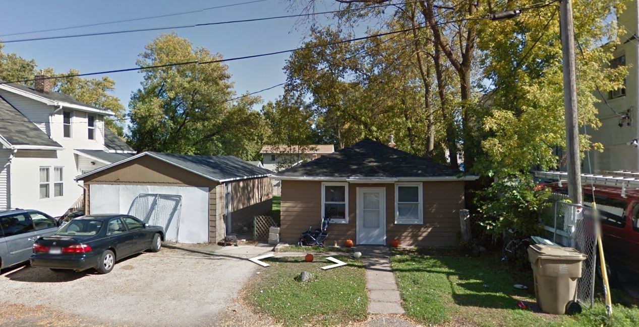 a small house with a car parked in front of it