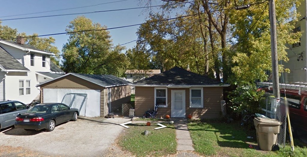 a small house with a car parked in front of it