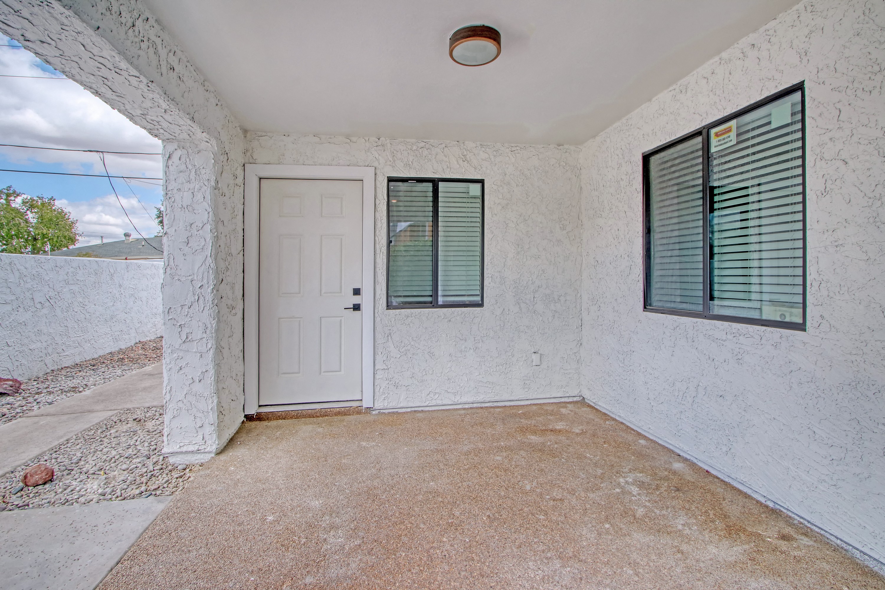 an empty room with a white door and a window