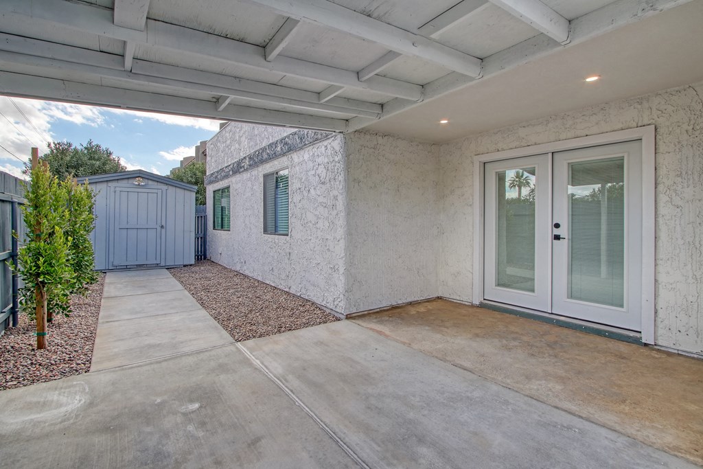 a patio with a door and a shed on the side