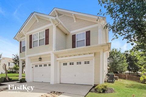 a white two story house with white garage doors