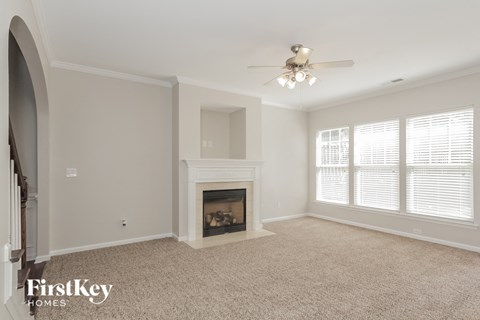 a living room with a fireplace and a ceiling fan
