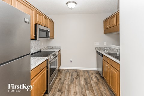a kitchen with wood flooring and stainless steel appliances