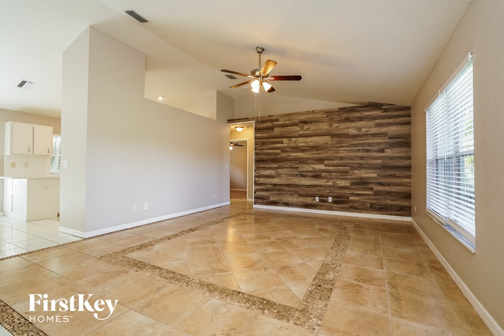 an empty living room with a wood accent wall