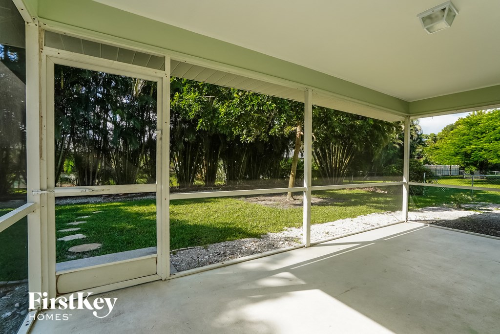 a view of the backyard from the porch of a home with glass doors