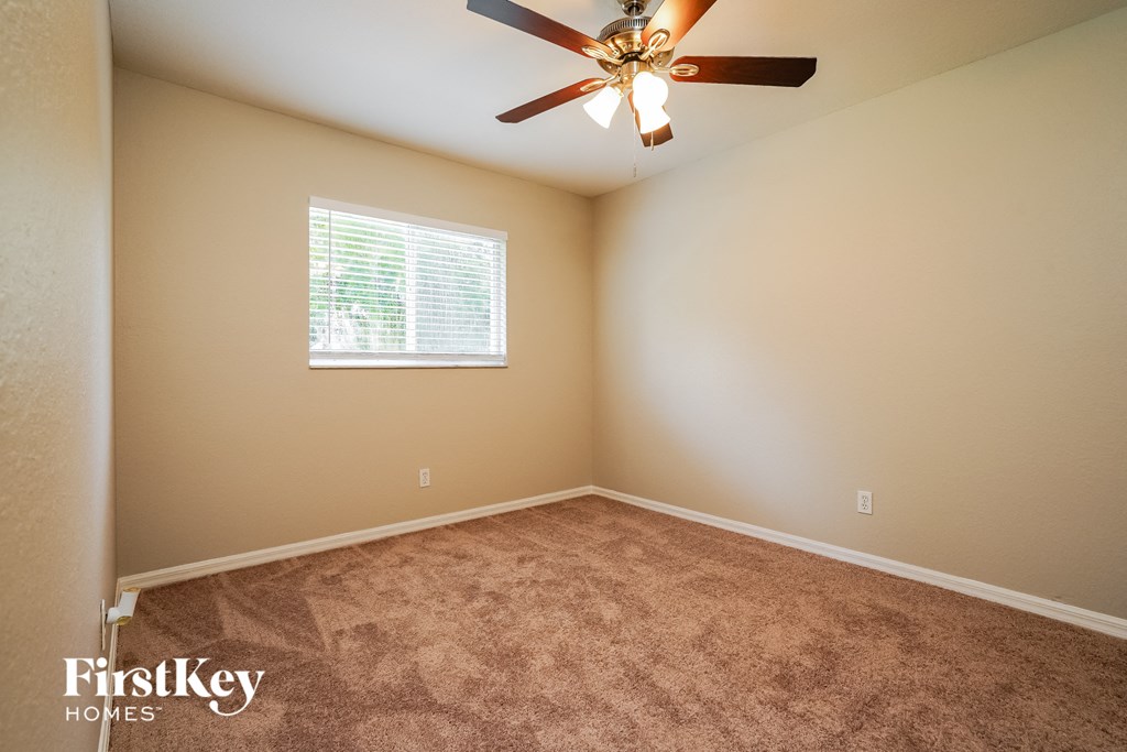 a bedroom with carpet and a ceiling fan