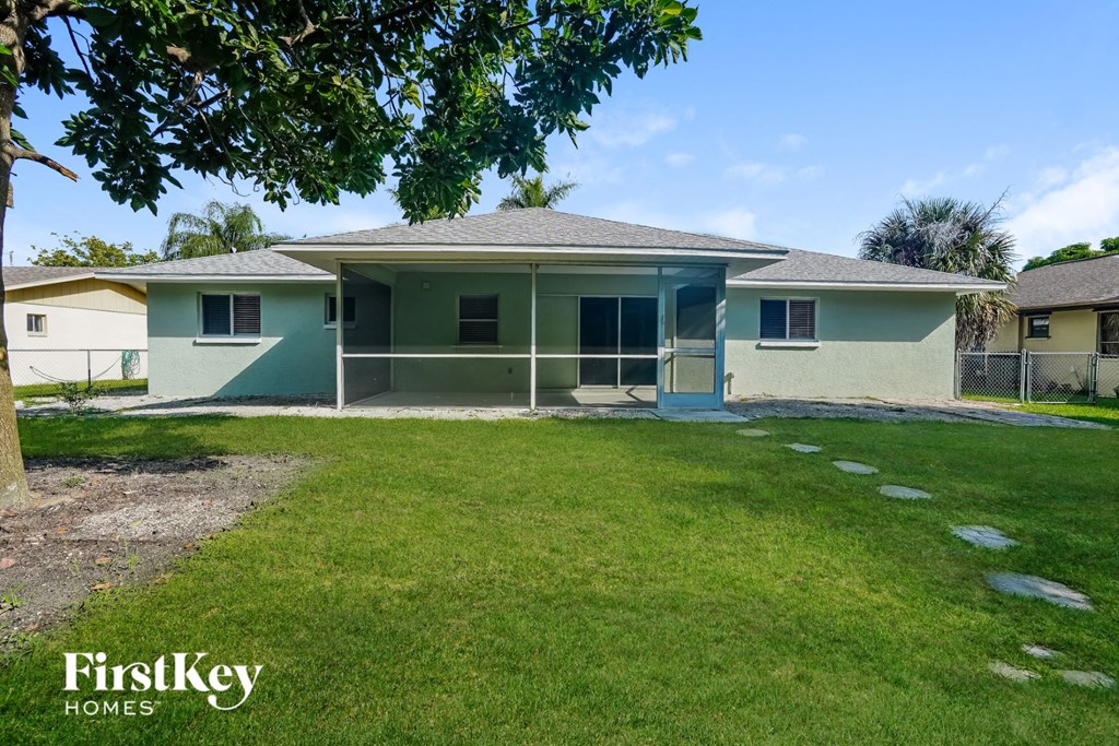 a green house with a lawn and a tree