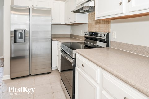 a white kitchen with stainless steel appliances and white cabinets