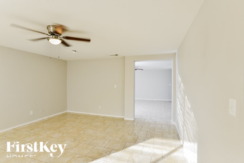 A room with a ceiling fan and a tiled floor.