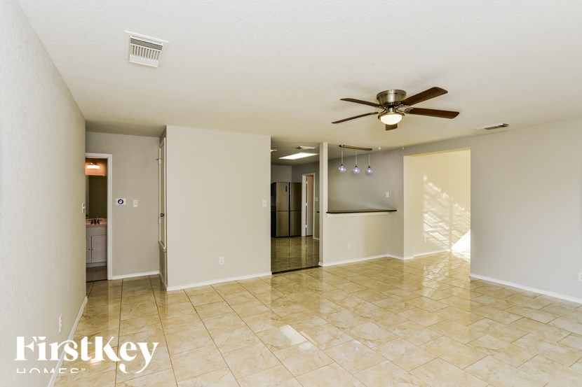 A spacious room with a ceiling fan and a tiled floor.