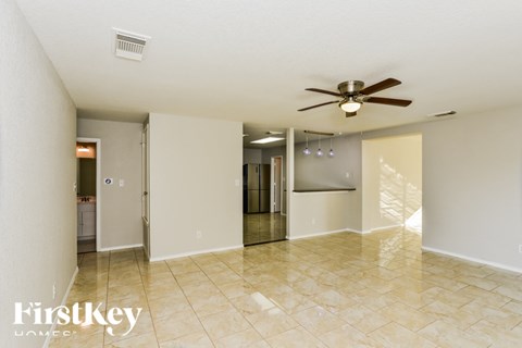 A spacious room with a ceiling fan and a tiled floor.