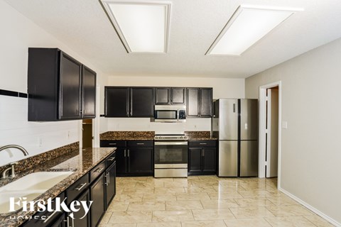 A kitchen with black cabinets and stainless steel appliances.
