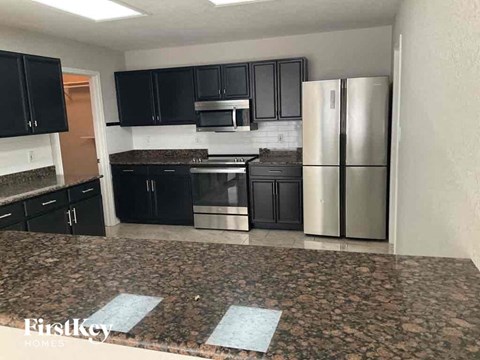a kitchen with black cabinets and stainless steel appliances