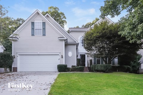 a white house with a lawn and a driveway