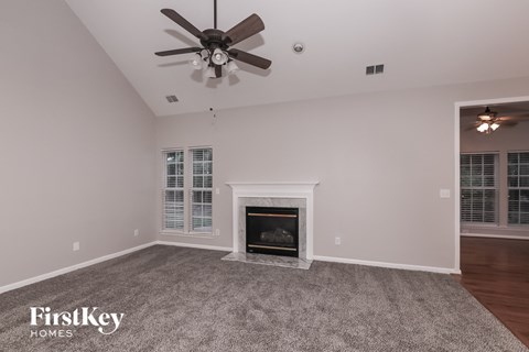 a living room with a fireplace and a ceiling fan