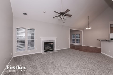 a living room with a fireplace and a ceiling fan
