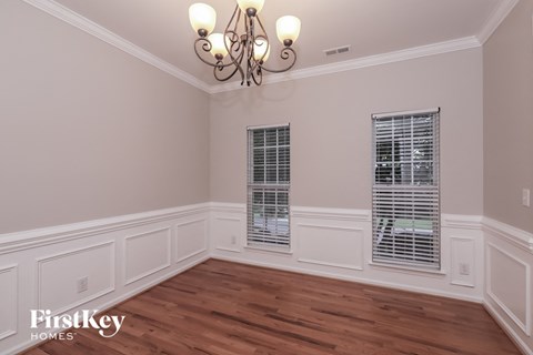 the dining room of a home with wood flooring and a chandelier