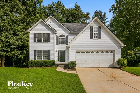 a white house with a white garage door and a driveway
