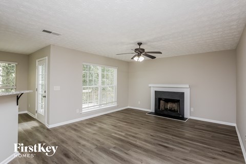 a living room with a fireplace and a ceiling fan