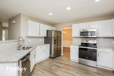 a kitchen with white cabinets and stainless steel appliances