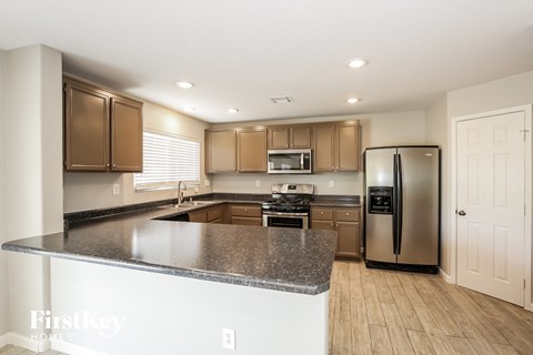 A kitchen with a granite countertop and stainless steel appliances.